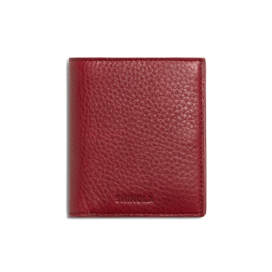 A closed Coin Bifold - Ruby wallet by Shinola, crafted from natural grain leather with a textured finish and embossed branding at the bottom, shown on a plain white background.