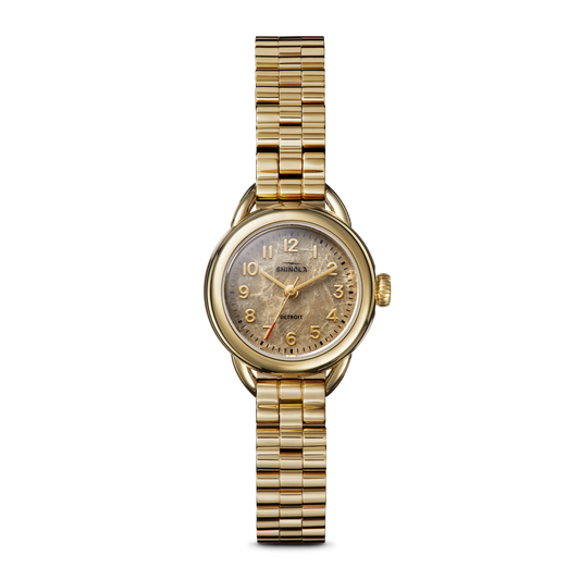 The Shinola Runabout Watch - Petoskey features a gold round face, gold band, and gold numbers. The slightly worn face shows the Shinola brand above center. This Detroit-assembled watch is shown on a plain white background.