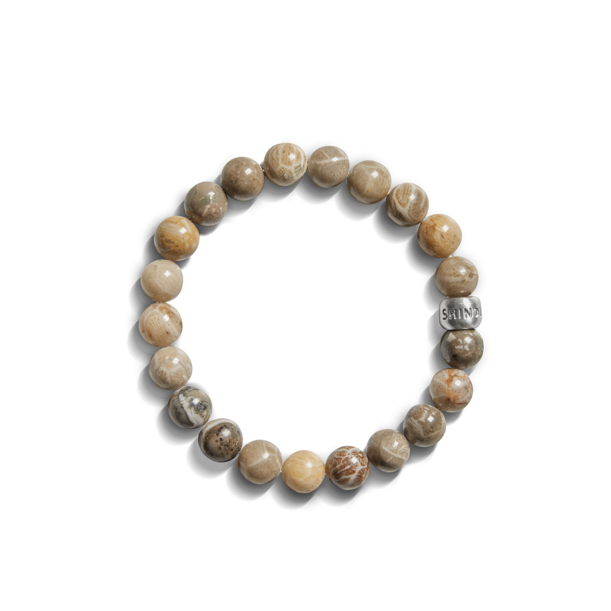 The Shinola 8mm Beaded Petoskey Bracelet features polished brown and beige Petoskey stone beads and a sterling silver “SAINT” bead—a distinctive Michigan jewelry piece.