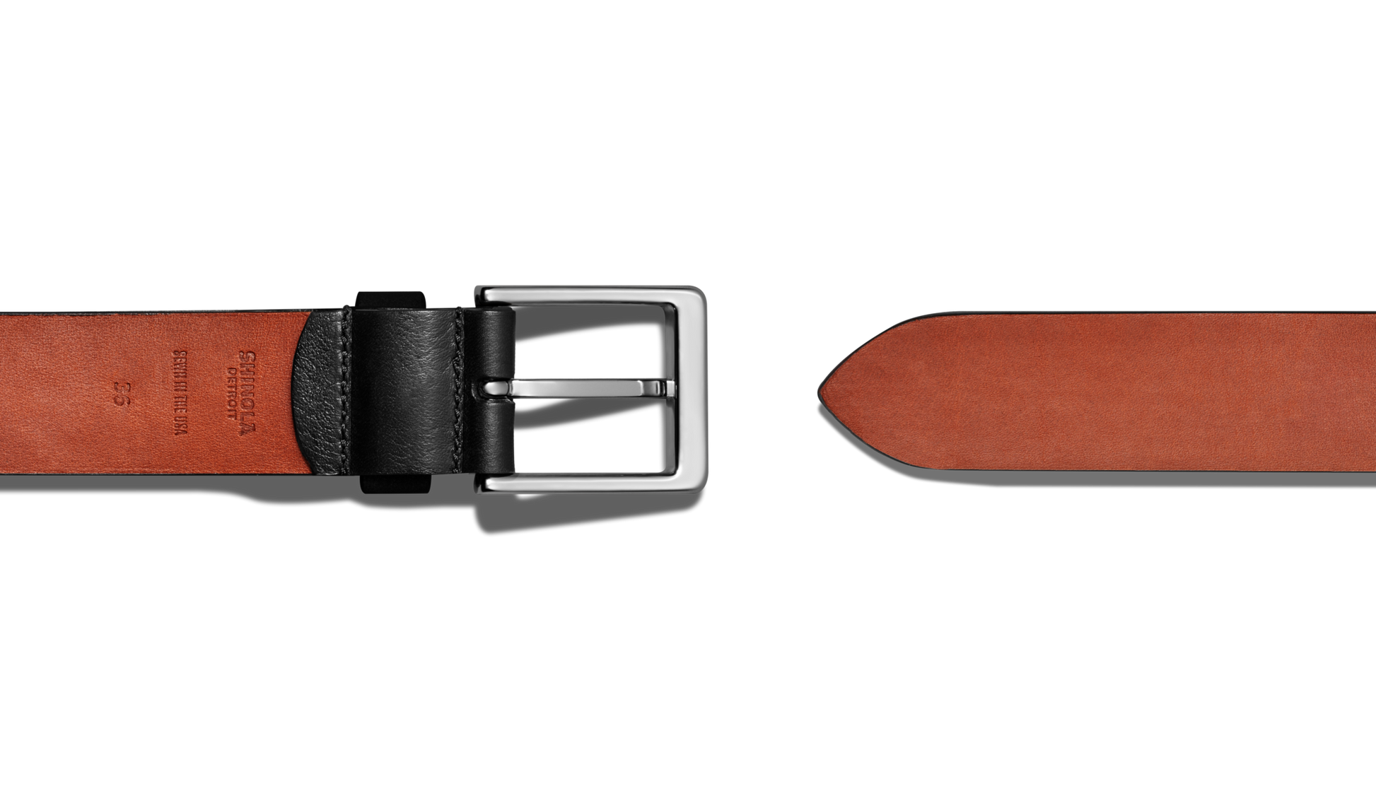The Shinola Lightning Bolt Keeper Belt - Black features a brown leather strap, black loop, and silver-tone rectangular buckle, displayed flat with the buckle on the left and tip on the right against a white background.