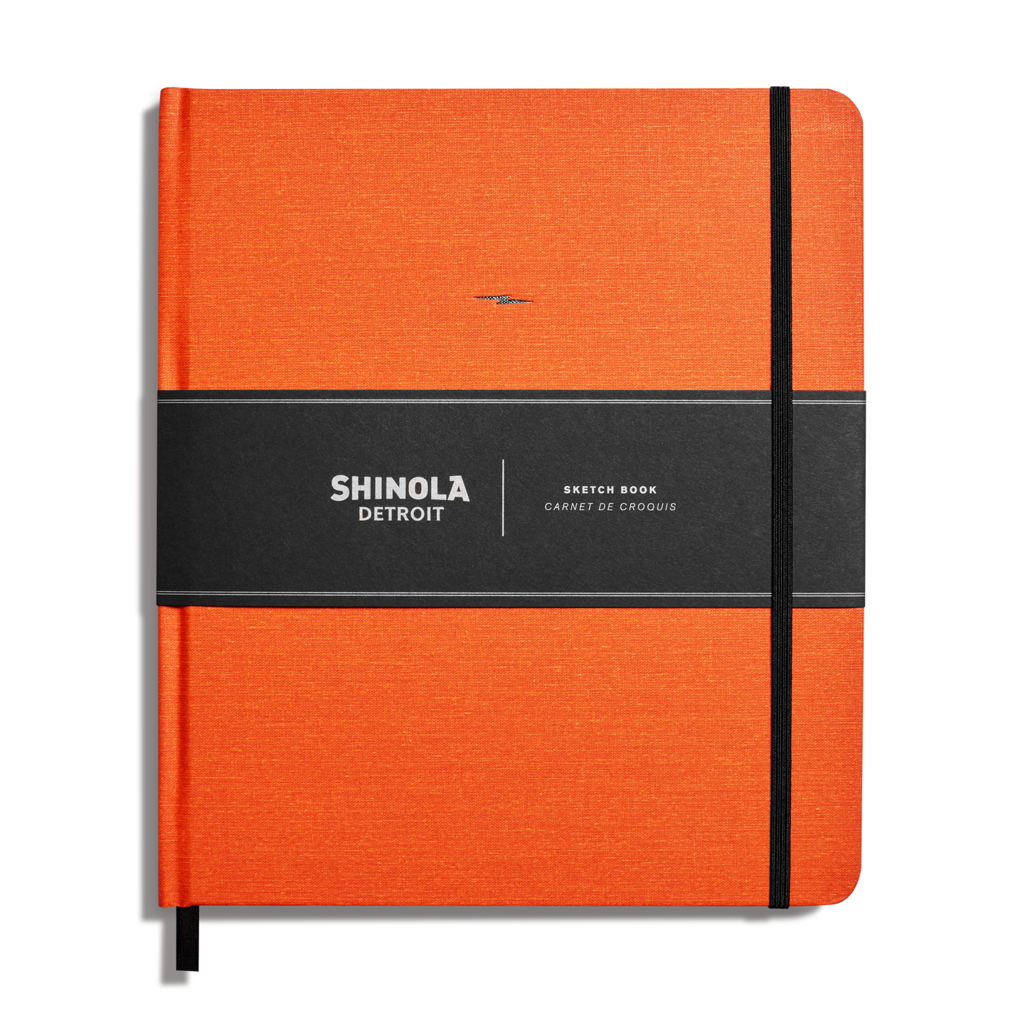 The Shinola Large Hard Plain Sketchbook in bold orange features a hard linen American-made cover, black elastic and paper bands, and is shown on a white background.