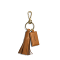 The Shinola Leather Tassel Keychain - Tan features a gold clasp, leather tassel, and a tag embossed with "Shinola," adding elegant style to your everyday essentials.