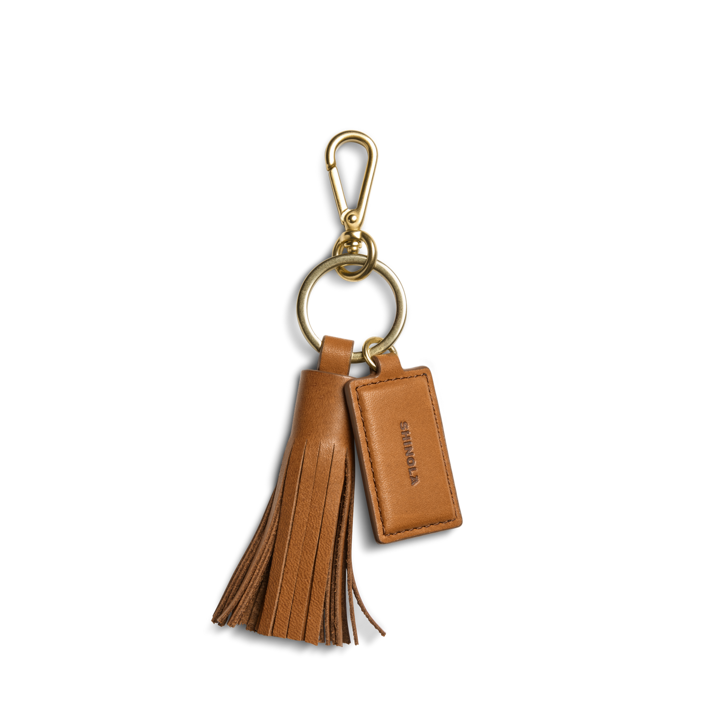 The Shinola Leather Tassel Keychain - Tan features a gold clasp, leather tassel, and a tag embossed with "Shinola," adding elegant style to your everyday essentials.