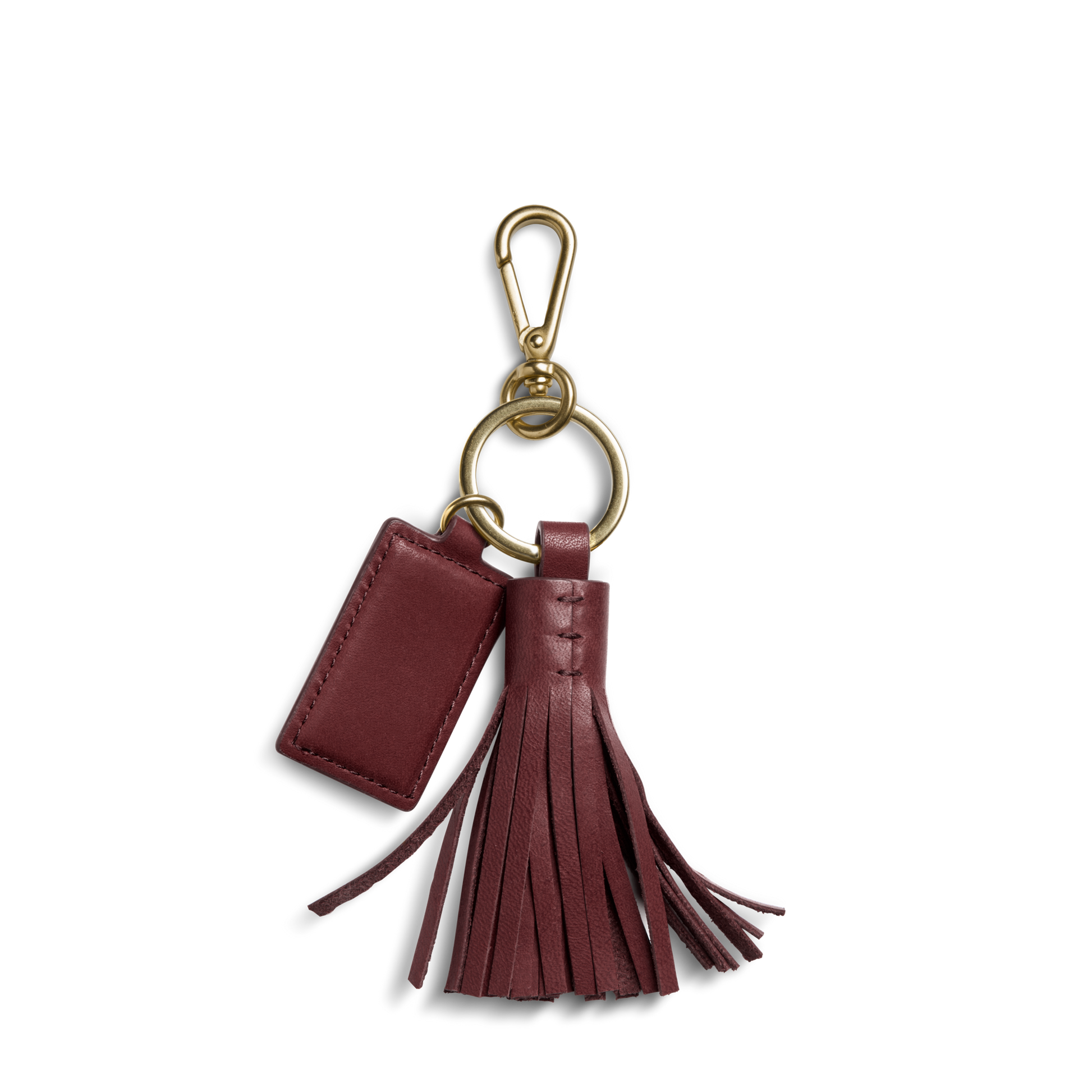 The Shinola Leather Tassel Keychain - Merlot features a chic rectangular tag and tassel on a gold keyring and clasp, perfect for personalizing your everyday essentials with style.