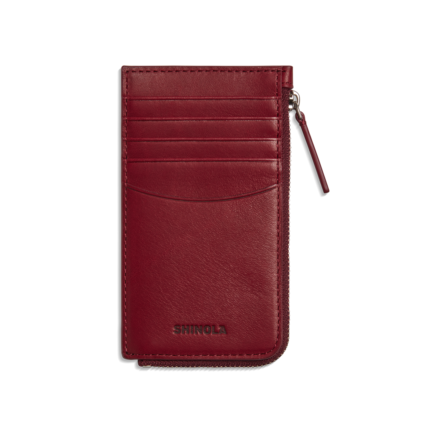 The Shinola Zip Around Card Case - Ruby features natural burgundy leather, several card pockets, a right zippered coin pocket, and "Shinola" embossed at the bottom.