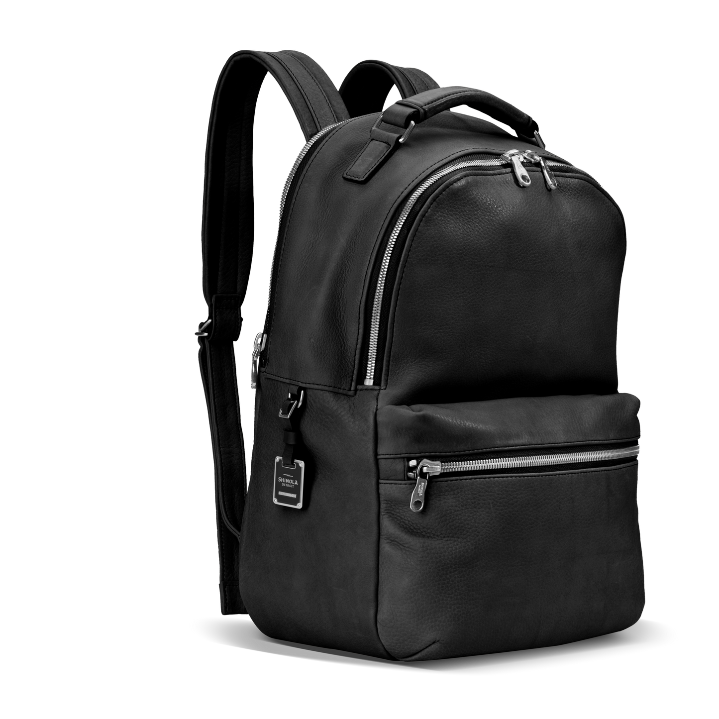 The Shinola Runwell Backpack in black premium leather features silver zippers, a front zip pocket, adjustable shoulder straps, and a top handle, displayed against a plain white background.