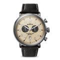 The Shinola Runwell Chronograph - Cream features a beige dial, black subdials, stainless steel case, black leather strap, Arabic numerals, two chronograph dials, and prominent pushers on the right.