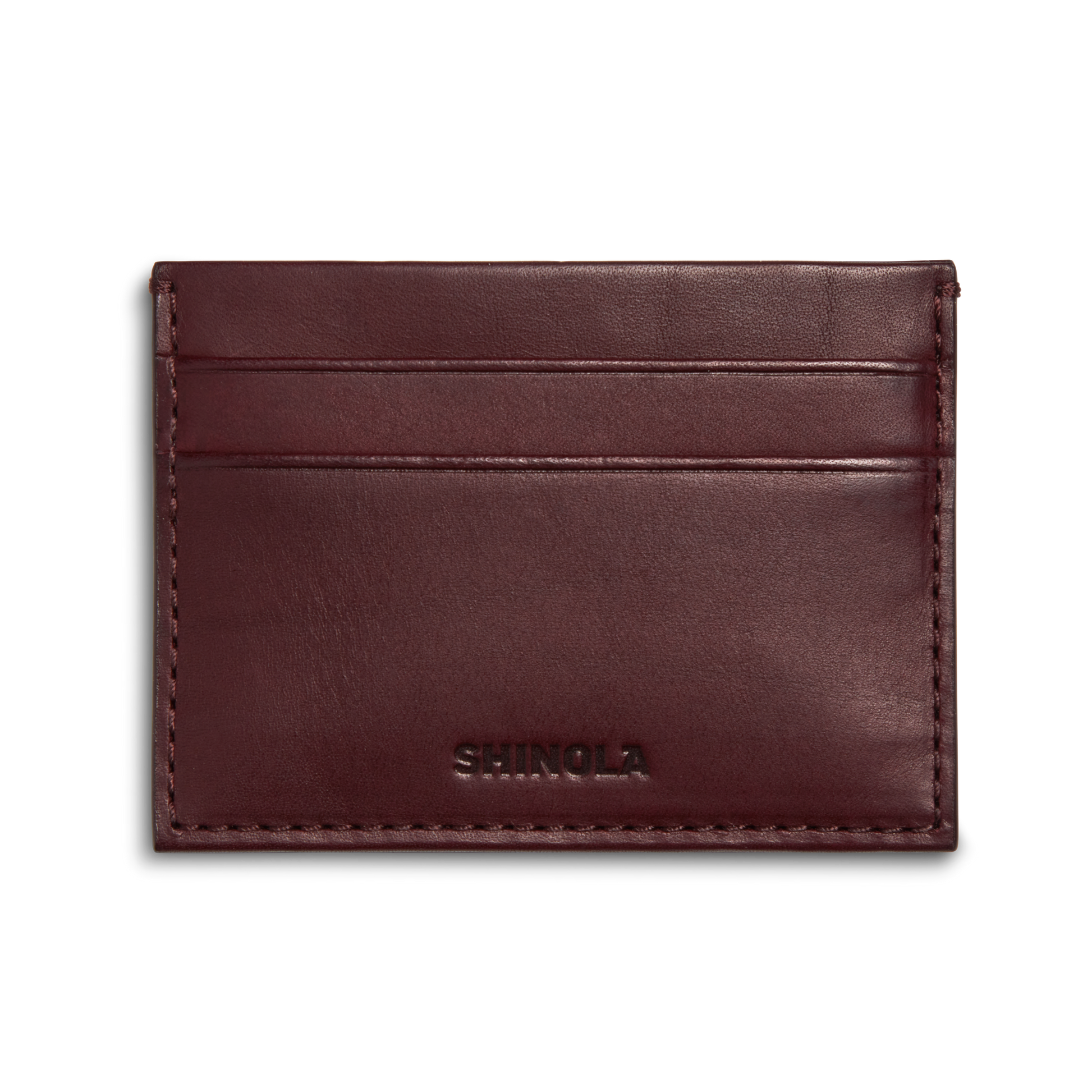 The Pocket Card Holder - Merlot by Shinola is a slim, rectangular dark brown vachetta leather card holder with two card slots and SHINOLA embossed at the bottom center.