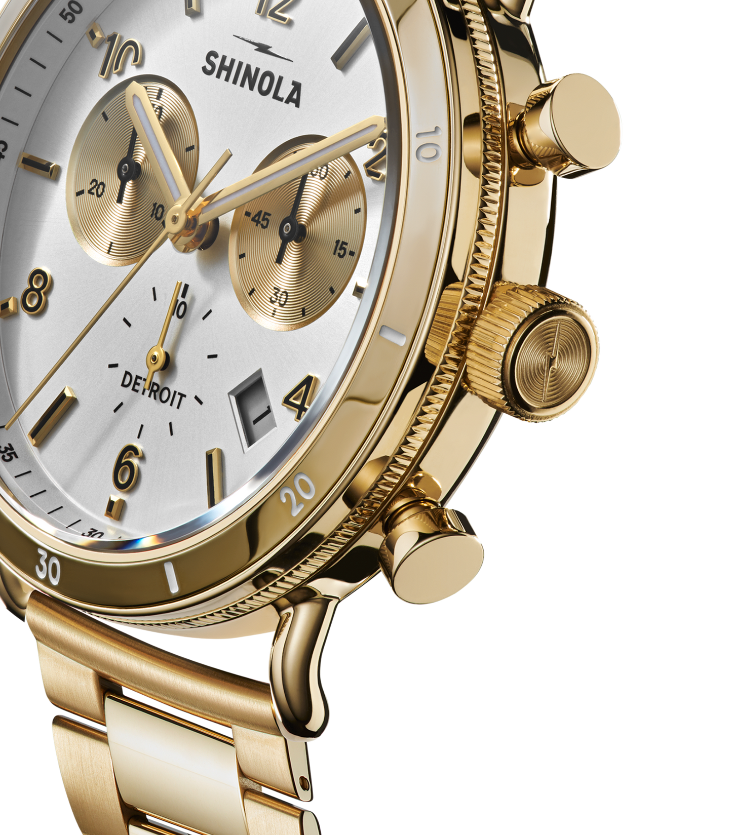 Close-up of a silver Shinola Canfield Sport Chronograph watch featuring a white and silver dial with three subdials, textured crown and pushers, and a silver stainless steel band. The word DETROIT appears on the watch face.