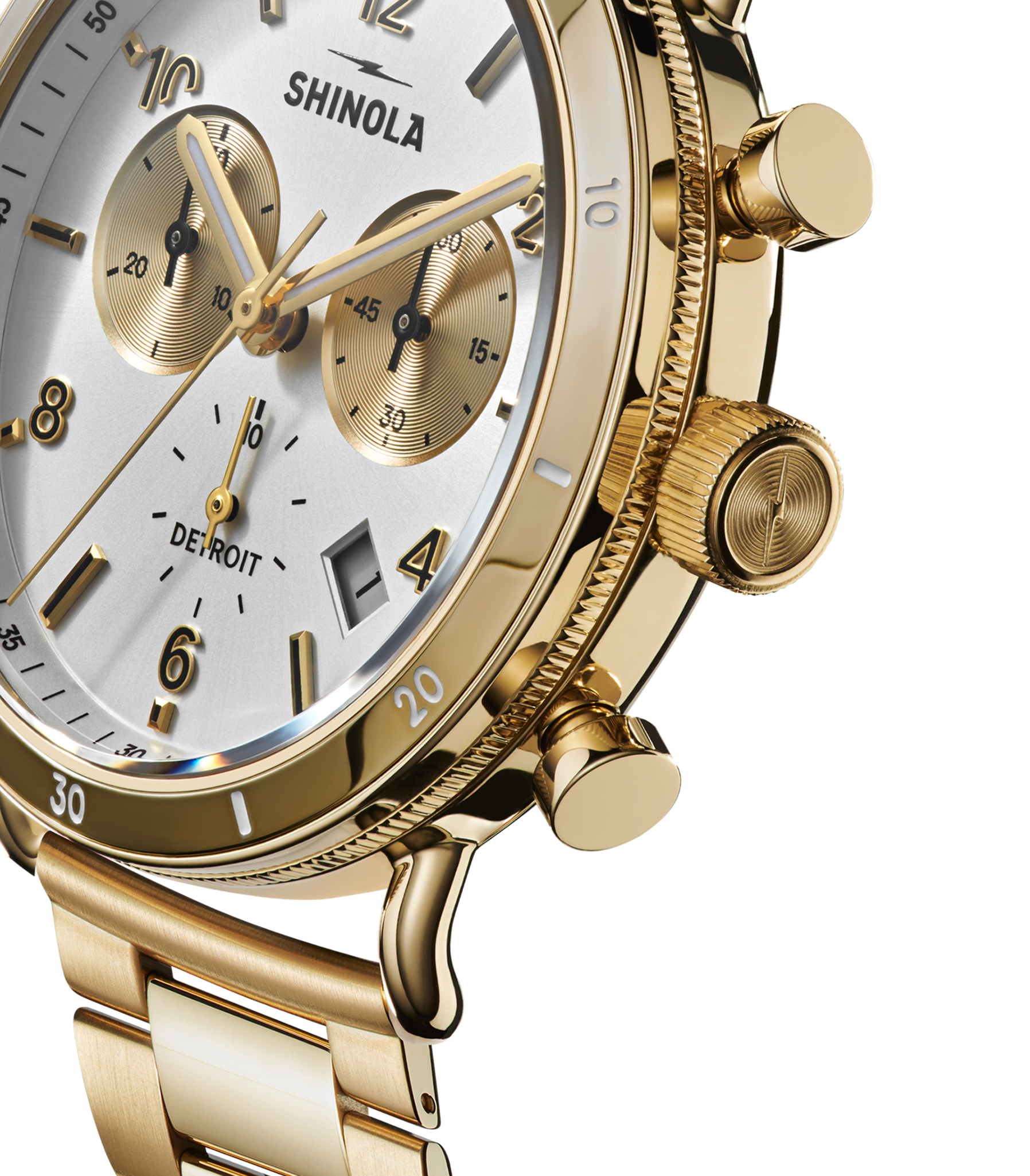 Close-up of a silver Shinola Canfield Sport Chronograph watch featuring a white and silver dial with three subdials, textured crown and pushers, and a silver stainless steel band. The word DETROIT appears on the watch face.