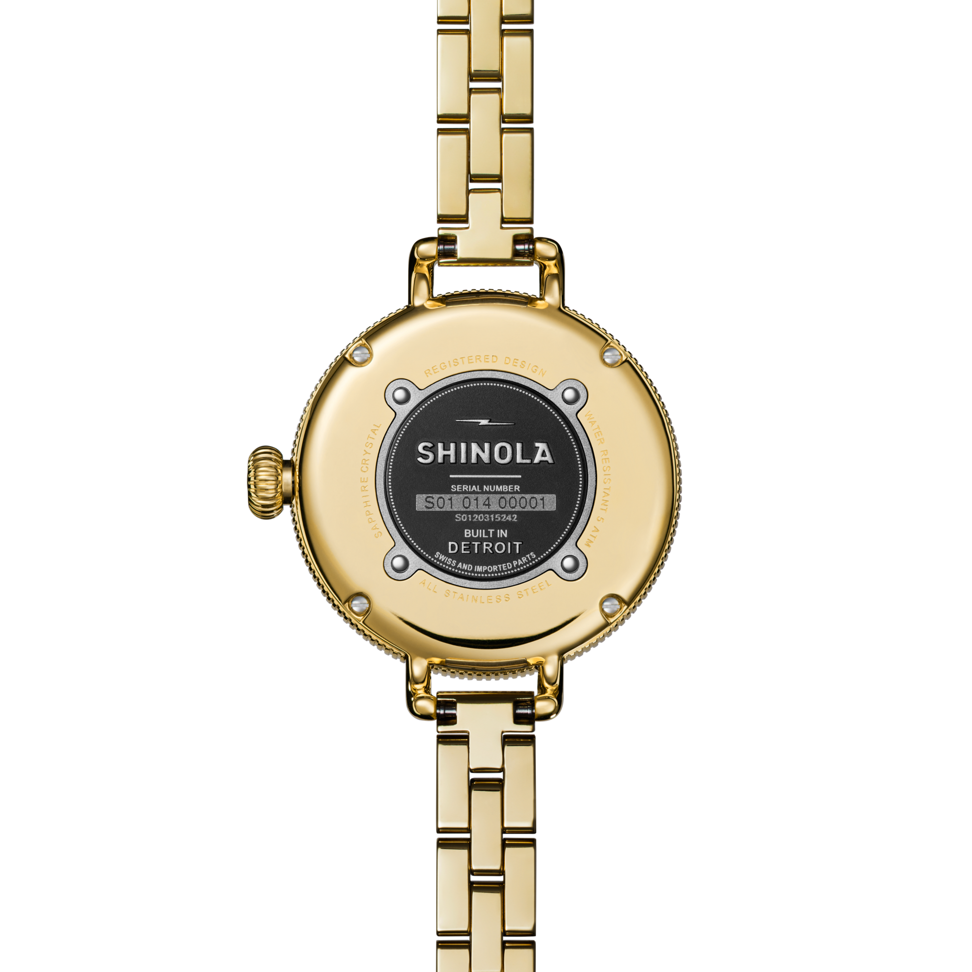 Close-up of the Shinola Birdy Watch - Lapis (gold, metal link band), showing the back with brand, serial number, "Built in Detroit" text, and four visible screws.