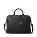 The Shinola Portfolio Briefcase in black features European grain leather, two handles, a detachable shoulder strap, silver hardware, zipper closure, and an embossed Shinola logo near the top center.
