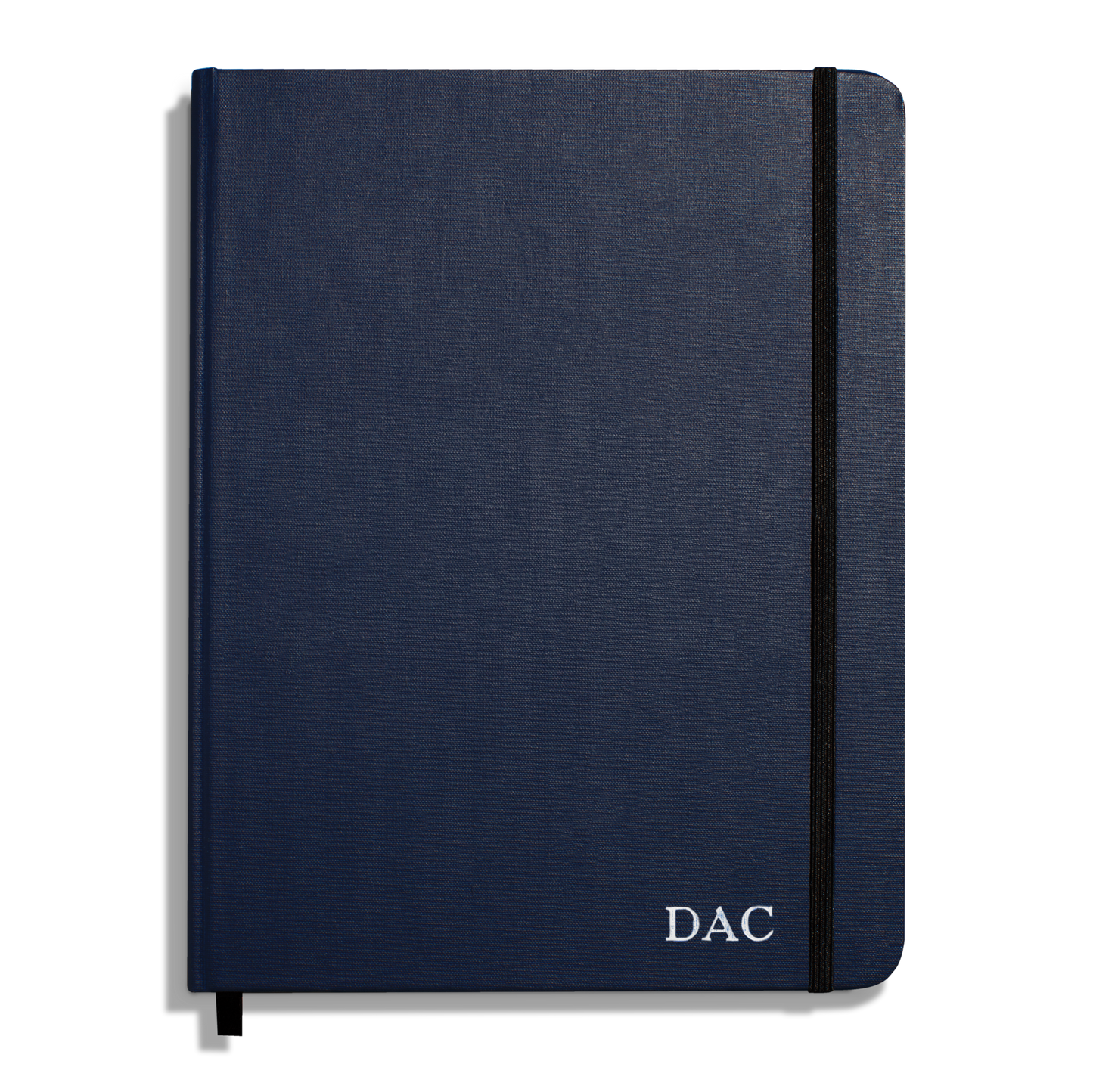 The Shinola Large Hard Ruled Journal in navy features a black elastic band and white "DAC" initials printed on the bottom right corner of the cover.