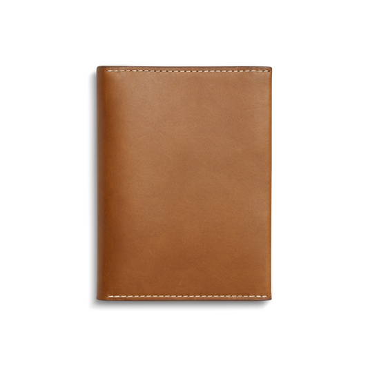 The Shinola Passport Holder - Tan is a rectangular Italian leather travel accessory with white edge stitching, shown closed against a plain white background.