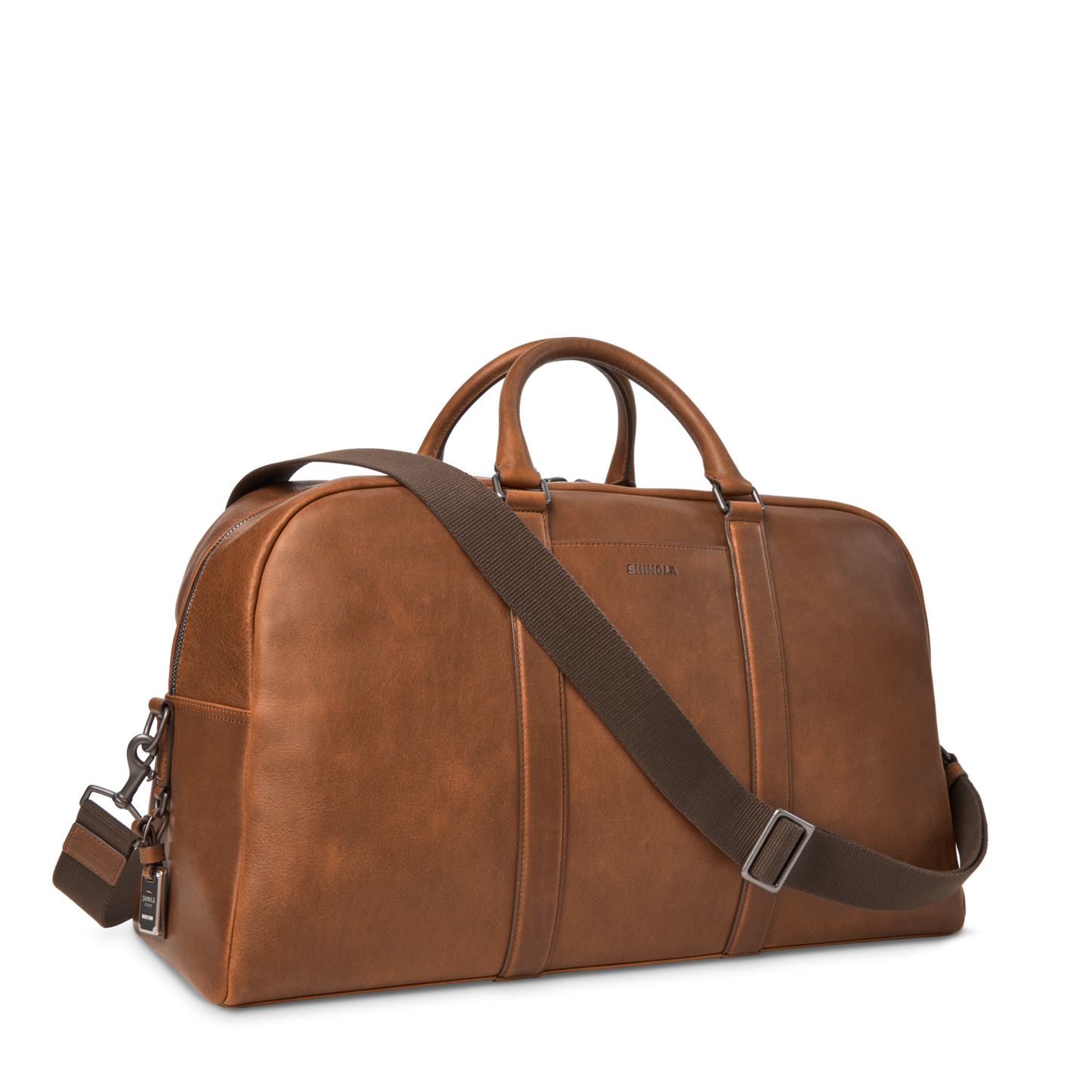 The Shinola Runwell Duffle Bag - Medium Brown is crafted from premium leather with double handles, a detachable shoulder strap, and metal hardware, shown against a plain white background.