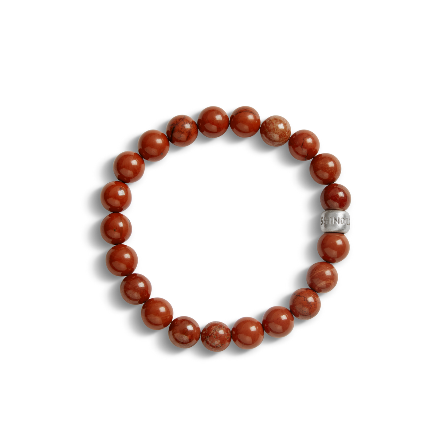 The Shinola 8mm Beaded Red Jasper Bracelet features polished red stones and a sterling silver accent bead engraved with the Shinola logo, shown on a white background.