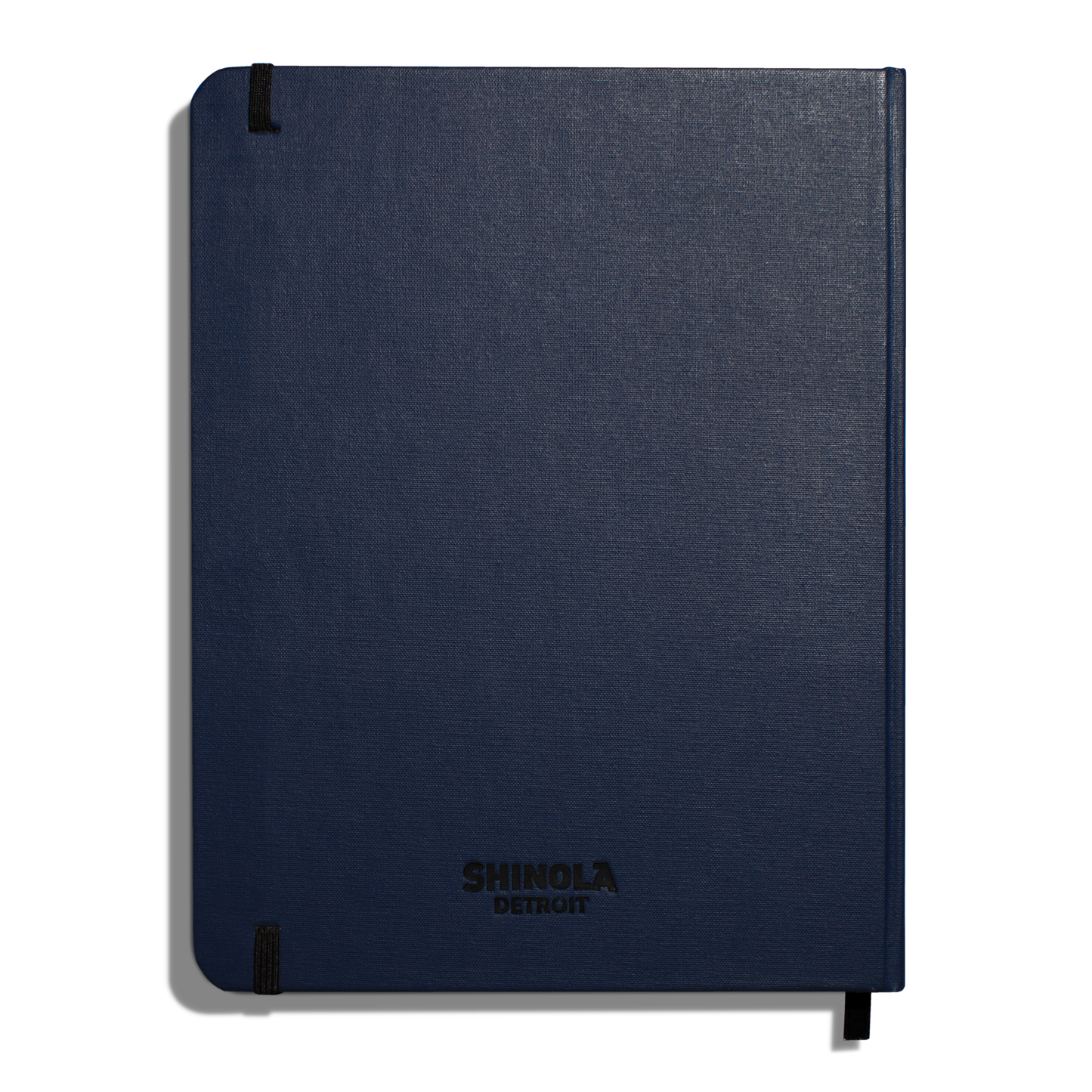 The Shinola Large Hard Ruled Journal in navy features durable linen covers, “Shinola Detroit” printed in black, acid-free paper, and secure black elastic bands for a stylish and long-lasting notebook.