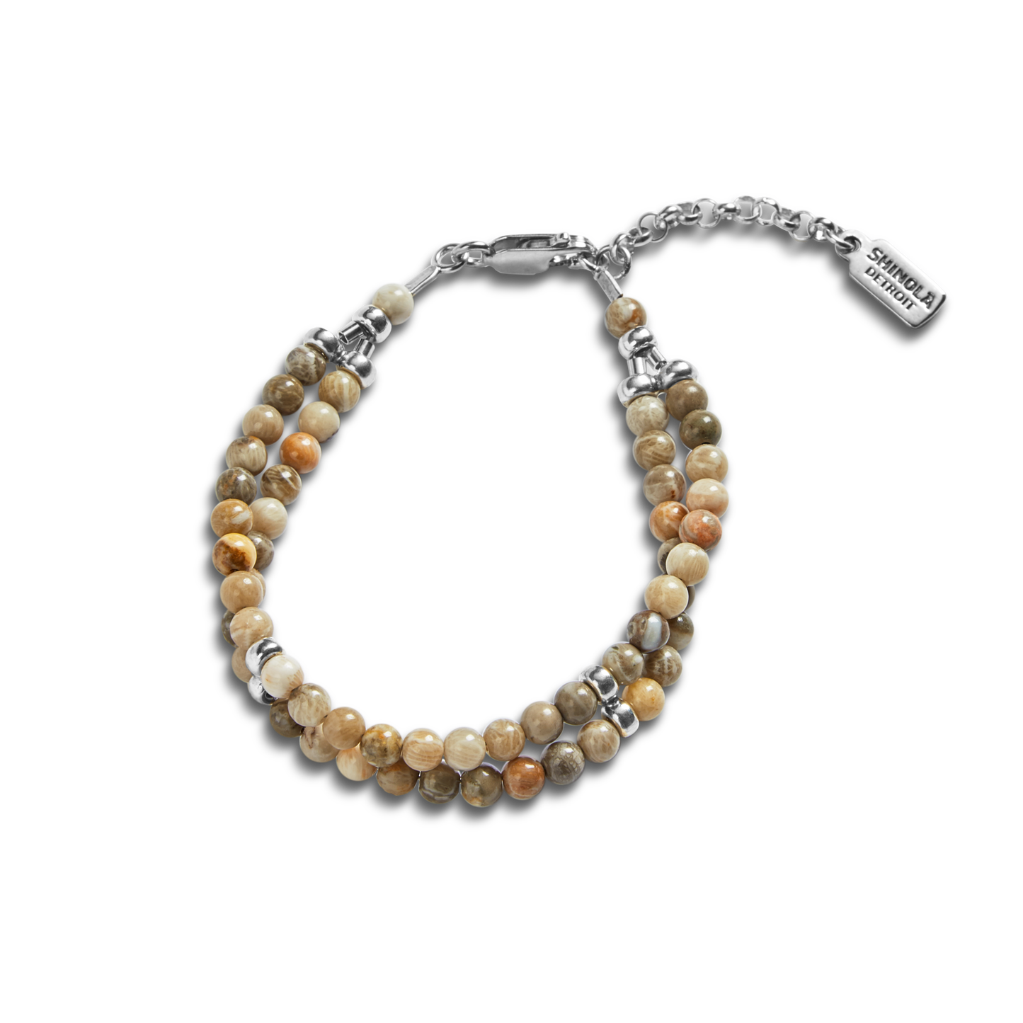 The Double Row Petoskey Beaded Bracelet by Shinola features round, earthy Petoskey stones, silver accents, a sterling silver closure, and a rectangular tag engraved with the Shinola name.