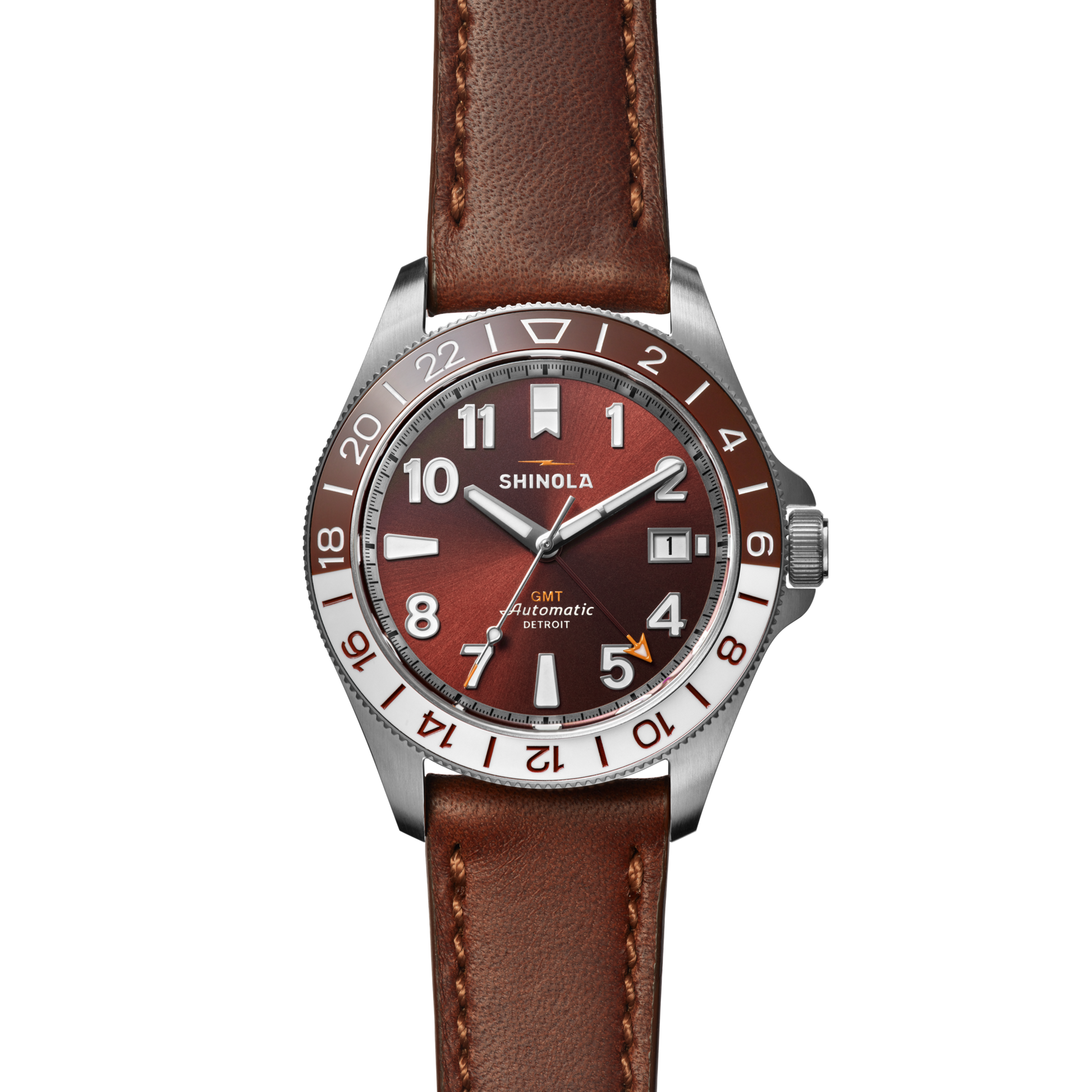 The Shinola Monster GMT Automatic Watch - Whiskey features a brown leather strap, stainless steel case, and red-brown dial with white numerals, date window, 24-hour bezel markers, and the Shinola brand—perfect for stylish travelers.