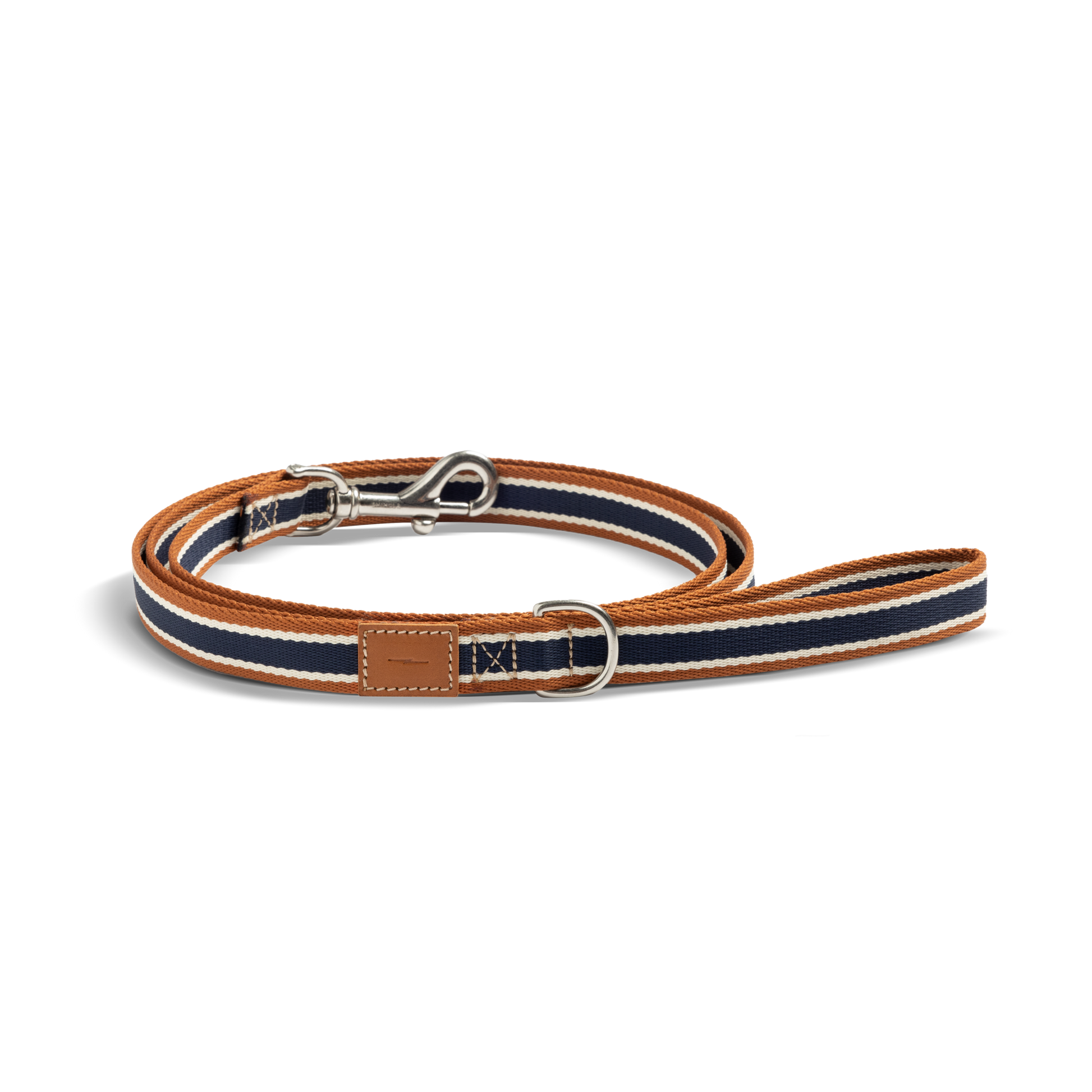 The Shinola Nylon Dog Leash - Brand Stripe features navy, white, and brown stripes, a silver clasp, D-ring, and stitched leather patch near the handle. Durable and stylish, it's shown coiled on a white background.