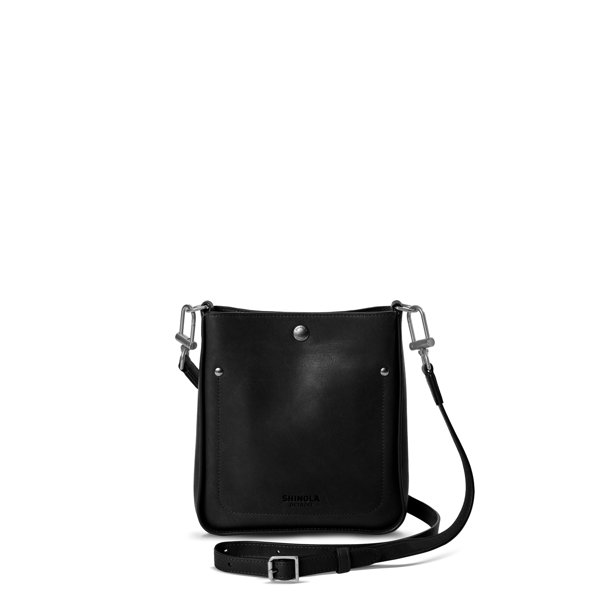 The Shinola Mini Pocket Crossbody Bag - Black features silver hardware, a front snap button, and an adjustable leather strap—ideal for carrying everyday essentials in style. Shown here against a plain white background.