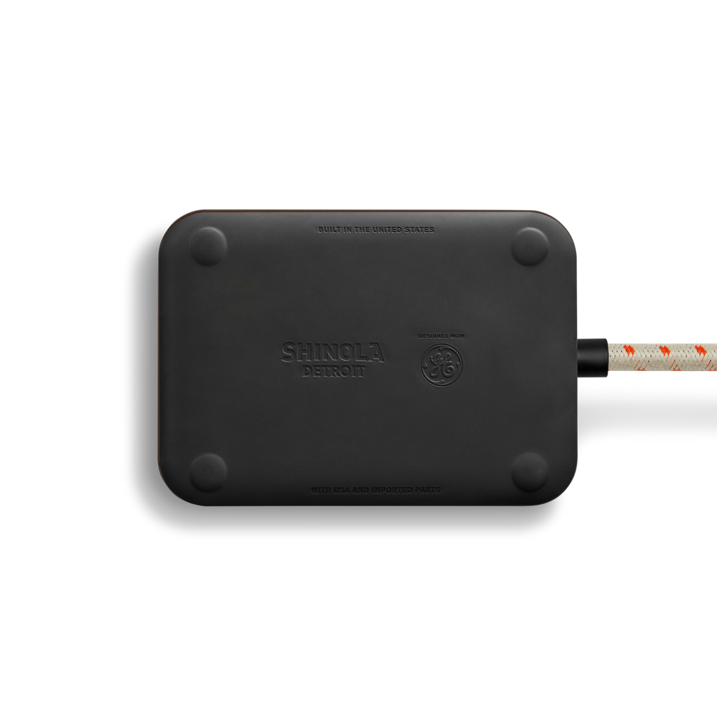 The Shinola 5 Port Power Supply - Black is a sleek rectangular charger with rounded corners, branded with embossed Shinola logos, and features a custom braided extension cord. It offers versatile USB-A and USB-C charging for your devices.