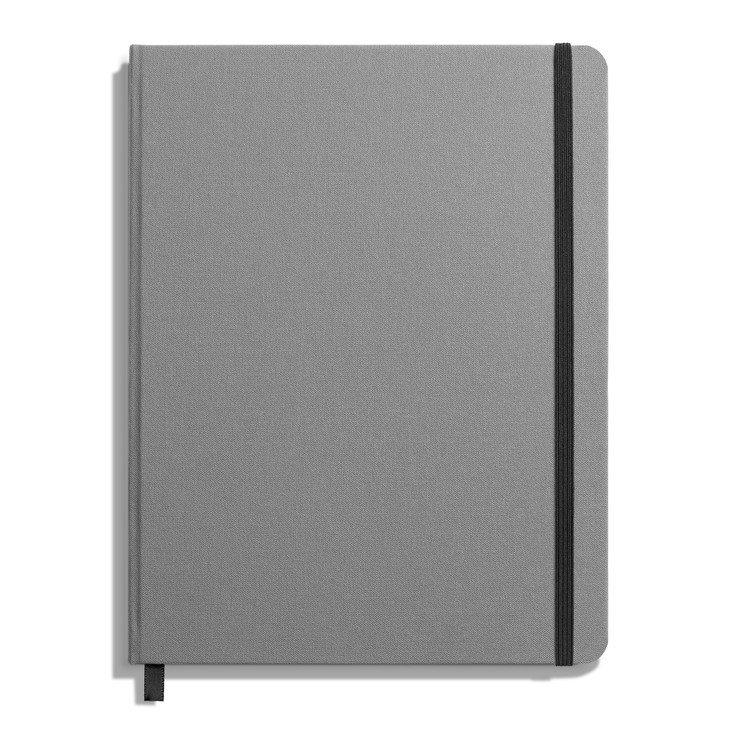 The Shinola Large Hard Ruled Journal in Stone features a closed gray linen cover, a black elastic band along the right edge, and a black ribbon bookmark against a white background.