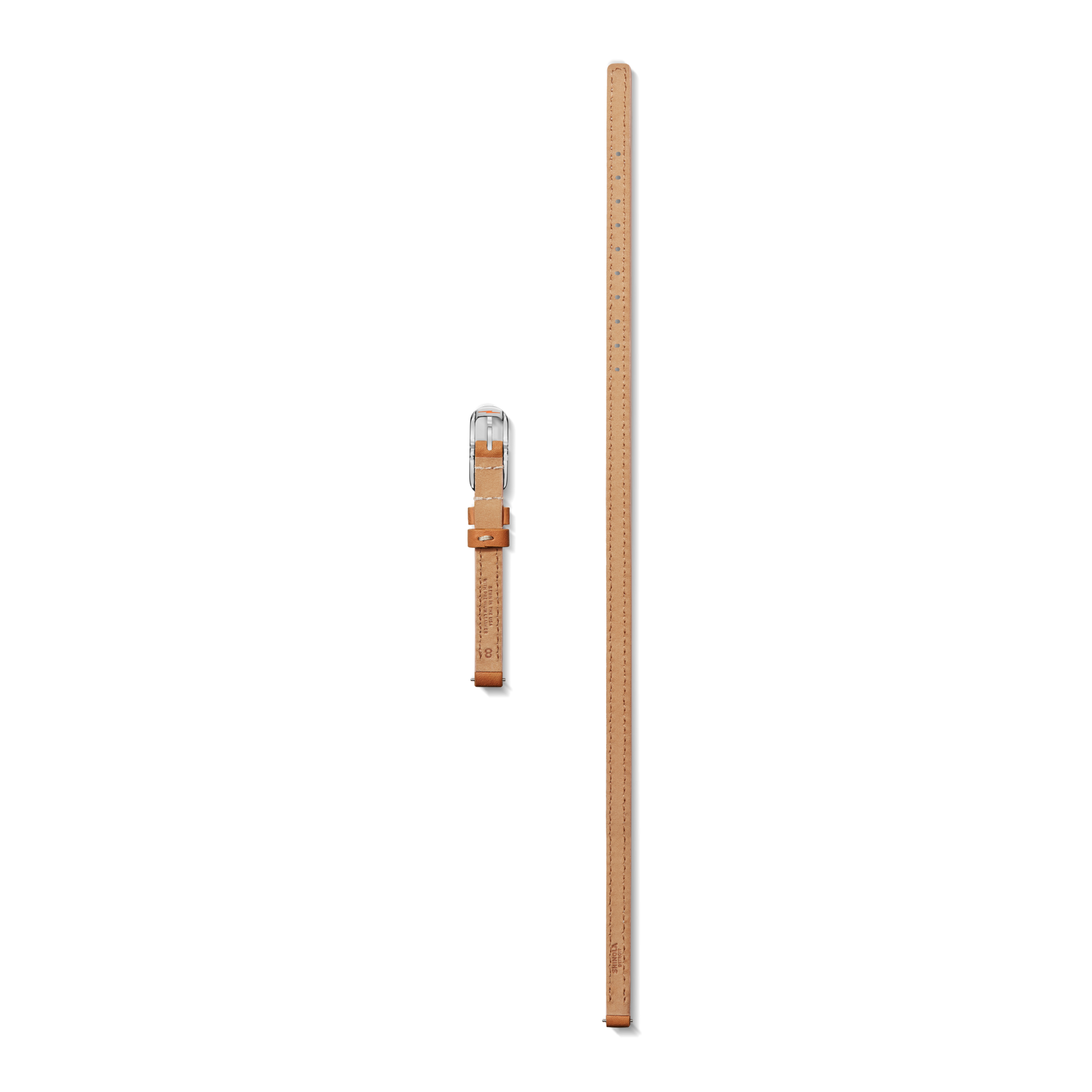 A Shinola 8mm Bourbon/Blush Reversible Leather Strap and a matching tan leather ruler with metal buckle are displayed against a plain white background.
