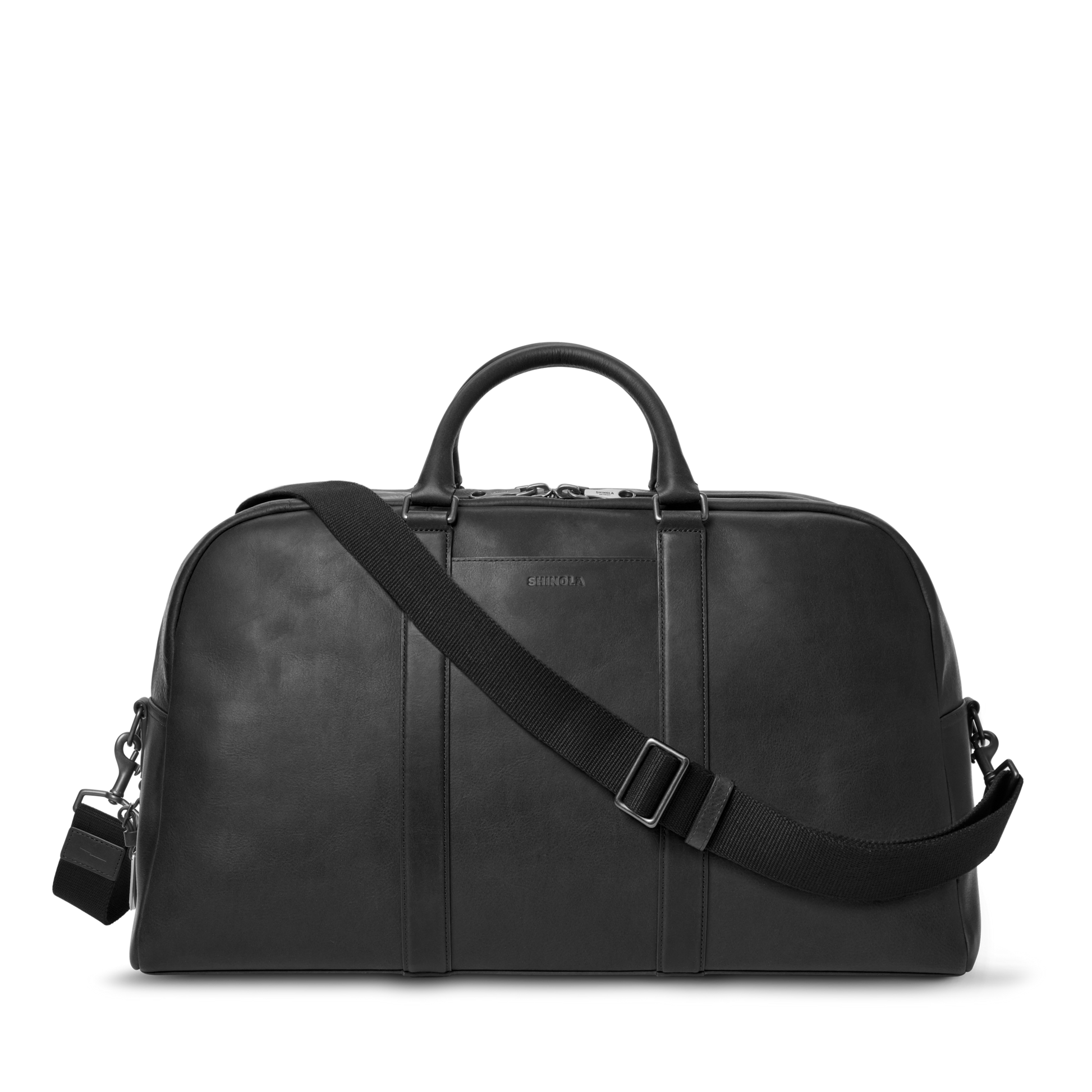 The Shinola Runwell Duffle Bag - Black features premium Navigator leather, two short handles, a detachable adjustable shoulder strap, and a small padlock—ideal as your next carry-on bag. Displayed against a white background.