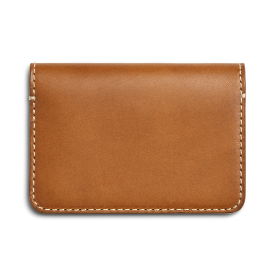 The Shinola Business Card Holder - Tan, crafted from Italian Vachetta leather with white edge stitching, is shown on a white background. Ideal for monogramming, it adds a custom touch to your professional essentials.