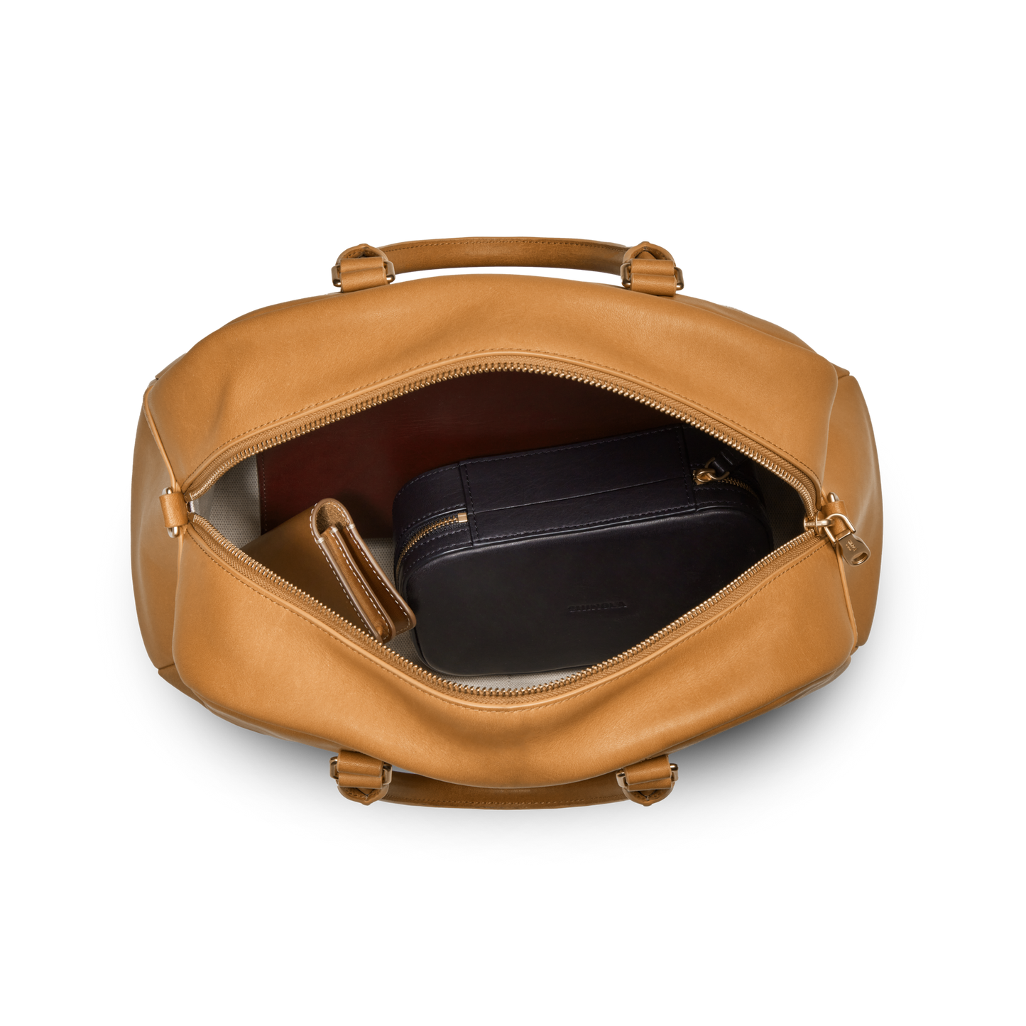 The Shinola Runwell Satchel - Honey is a premium tan natural leather duffel bag shown unzipped to reveal a black zippered pouch and brown wallet inside, all against a white background.