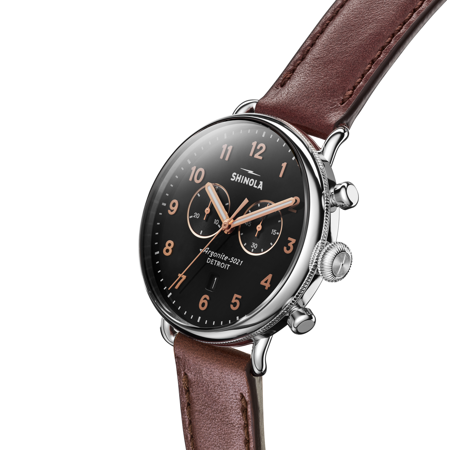 The Shinola Canfield 2 Eye Chrono - Black wristwatch, featuring a brown leather strap, black dial, rose gold markers and hands, and two subdials, is shown angled on a white background.