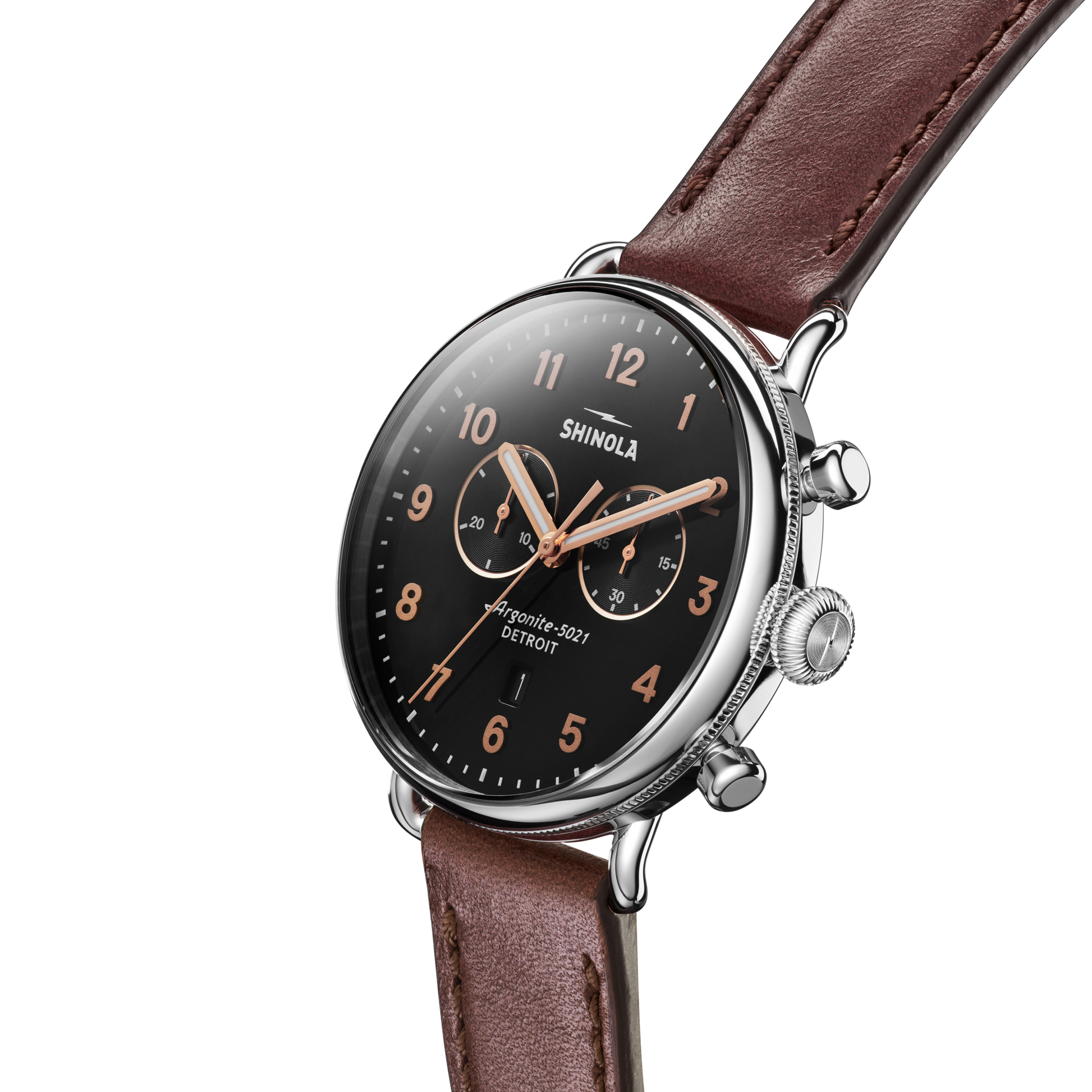 The Shinola Canfield 2 Eye Chrono - Black wristwatch, featuring a brown leather strap, black dial, rose gold markers and hands, and two subdials, is shown angled on a white background.