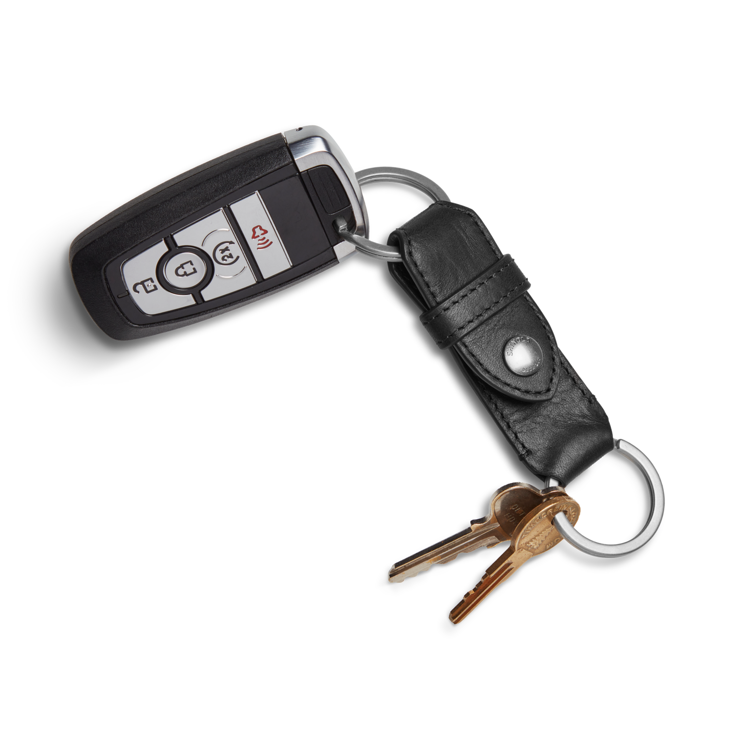 The Shinola Leather Valet Key Fob - Black holds a black car key fob and two brass house keys on a metal keyring with a black leather strap, arranged on a white background.