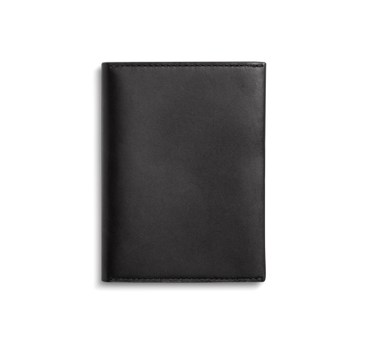 The Shinola Passport Holder - Black is a closed, rectangular Italian Vachetta leather accessory with clean edges and visible stitching, shown against a plain white background for an elegant travel look.