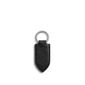 The Shinola Leather Monogram Key Fob - Black features natural leather with a pointed end, silver metal ring, embossed stitching, and the Shinola logo. Displayed on a plain white background.