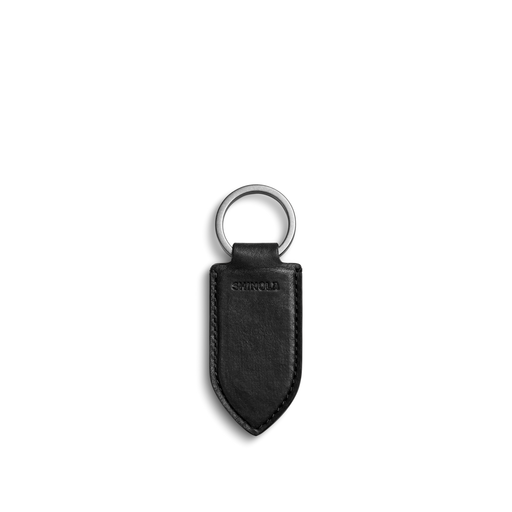 The Shinola Leather Monogram Key Fob - Black features natural leather with a pointed end, silver metal ring, embossed stitching, and the Shinola logo. Displayed on a plain white background.