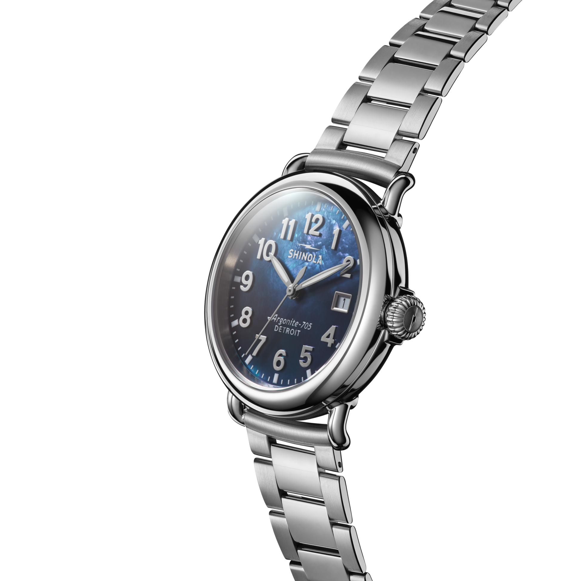 The Shinola Runwell Watch - Cadet Blue features a stainless-steel bracelet, round case, and cadet blue mother of pearl dial with silver numerals and hands. Shown angled on a white background.