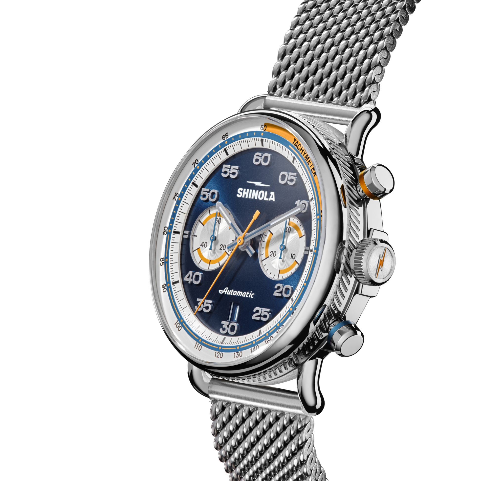 A close-up of the Shinola Canfield Speedway Open Road Automatic Chronograph Watch - Blue, featuring a blue dial, silver mesh band, chronograph subdials, tachymeter scale, and orange accents on a plain white background.