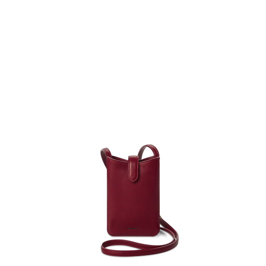 The Shinola Bixby Phone Crossbody in Ruby is a small, deep red natural leather bag with a slim strap, open top, and card slip pocket, shown against a plain white background.