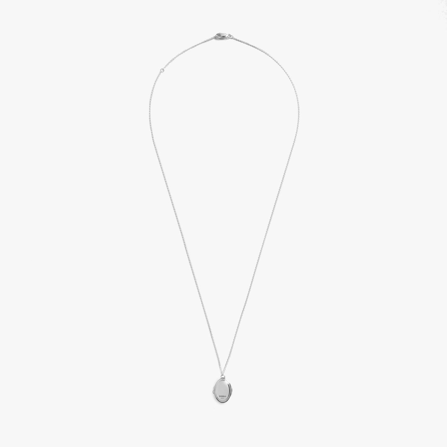 The Shinola Heirloom Petite Locket Necklace in sterling silver features a thin chain and small oval pendant, ideal for engraving, shown against a plain white background.