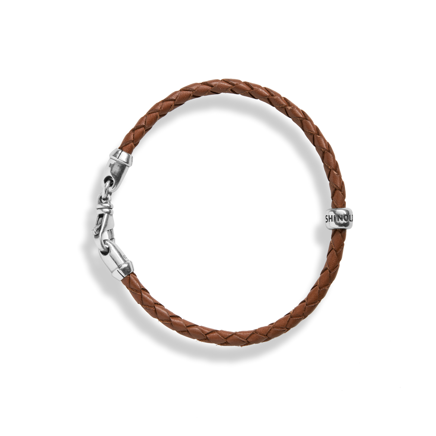 The Shinola Single Wrap Woven Leather Bracelet in tan features a sterling silver clasp and an engraved silver bead, shown on a white background.