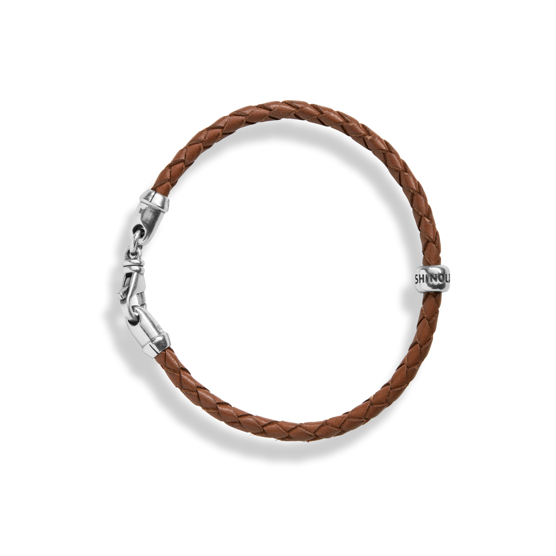 The Shinola Single Wrap Woven Leather Bracelet in tan features a sterling silver clasp and an engraved silver bead, shown on a white background.