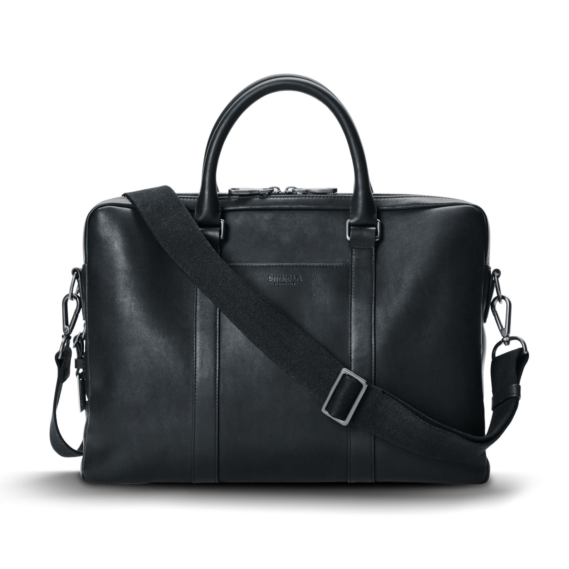 A shinola.momputer Briefcase in black, featuring dual top handles, a detachable shoulder strap, and subtle stitching details, set against a plain white background.
