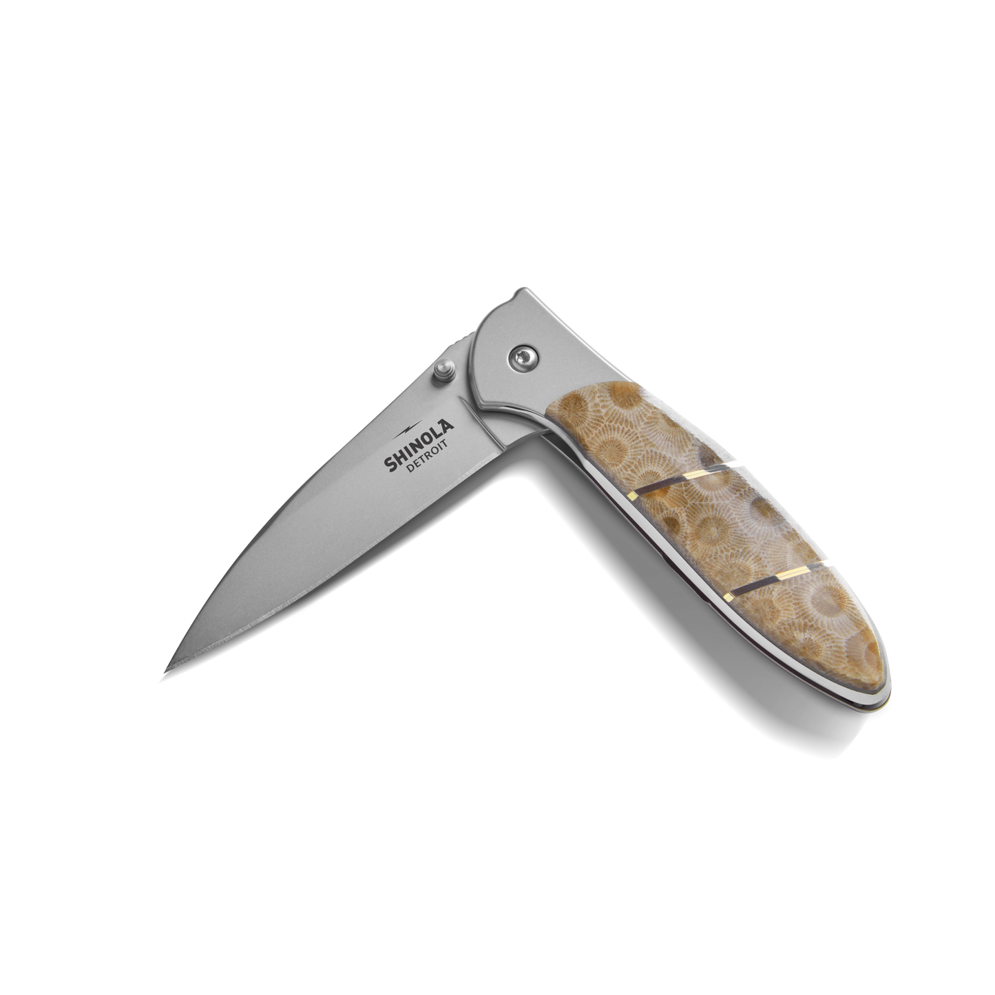 The Shinola + Kershaw Petoskey Stone Pocket Knife features a partially open silver blade engraved with "Shinola Detroit" and a handle inlaid with polished brown and beige Petoskey Stone.