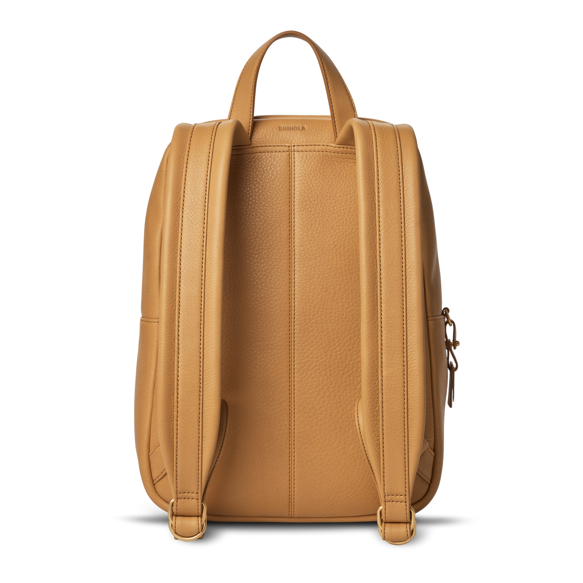 The Small Runwell Backpack - Honey by Shinola is shown from the back, highlighting its natural grain leather, two padded shoulder straps, top handle, and textured finish. The zipper and main compartment are not visible in this view.