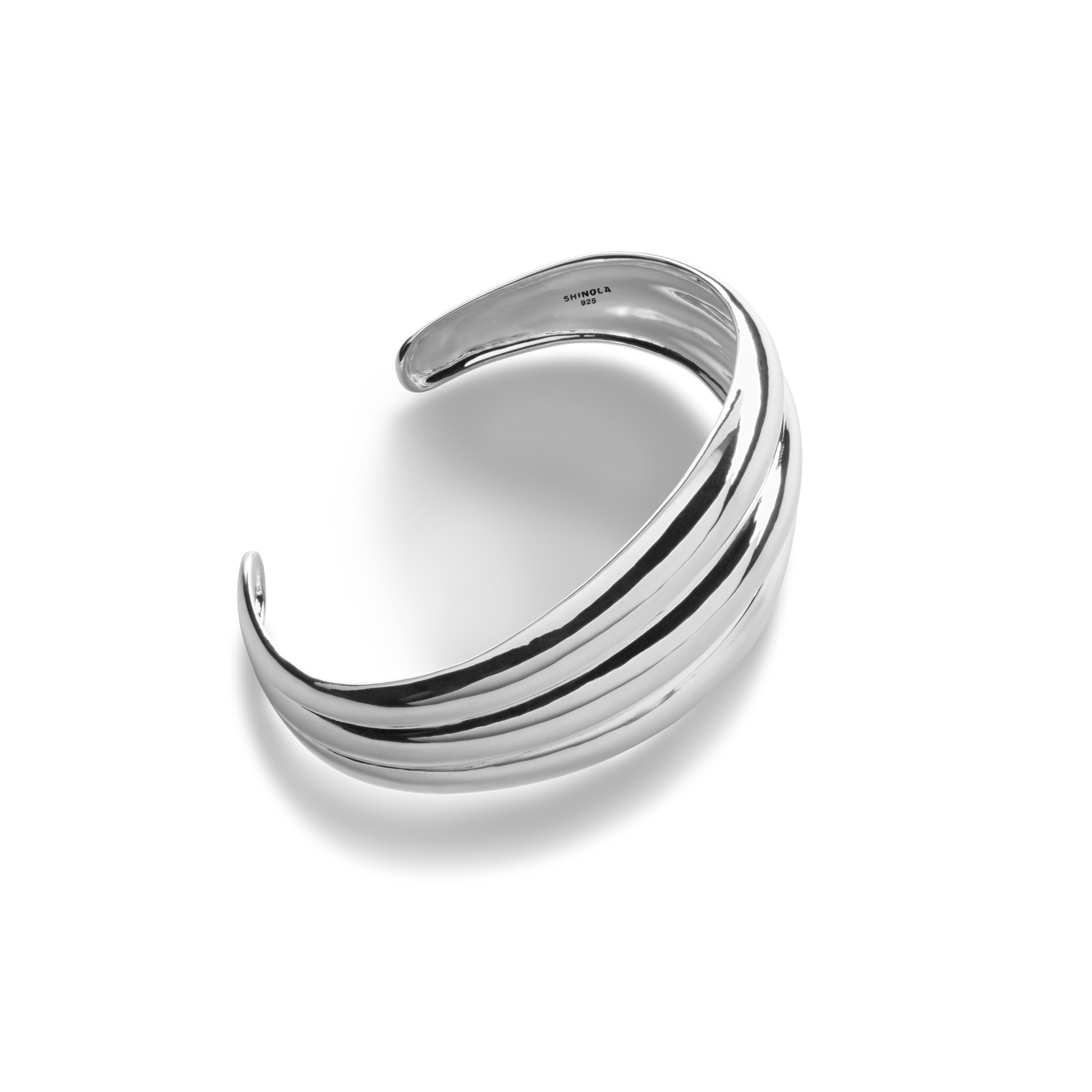 The Signature Silver Statement Cuff by Shinola features three raised, parallel ridges on a polished sterling silver band, elegantly displayed against a white background.