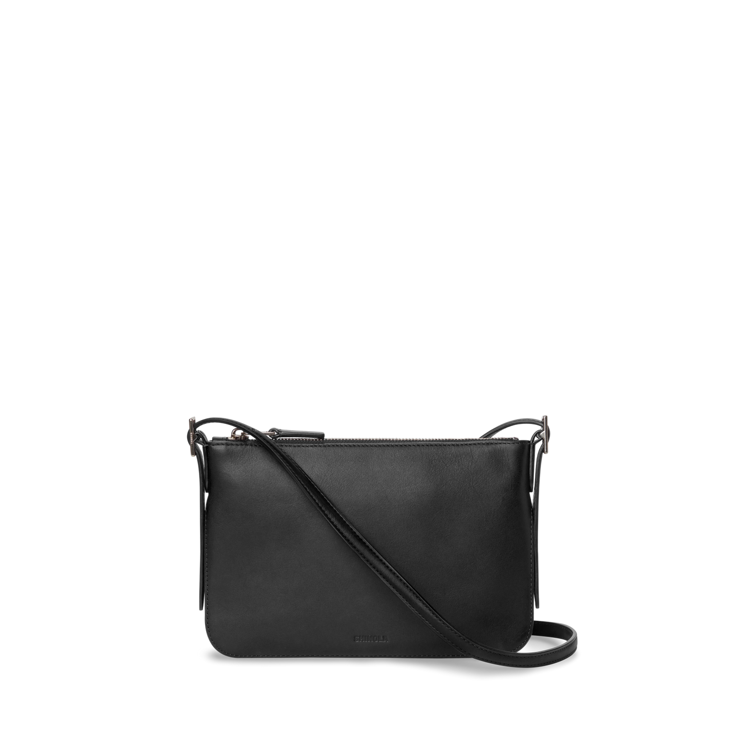 The Shinola Small Bixby Crossbody - Black is a slim natural leather bag with a zipper closure and adjustable strap, making it an ideal everyday accessory. Shown here against a plain white background.