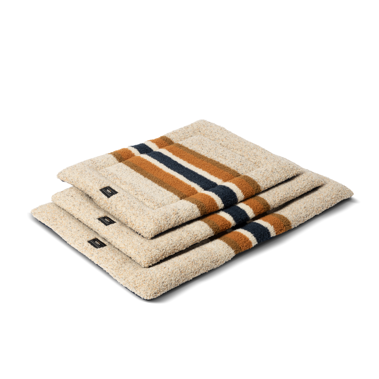 Three folded Stripe Brown Crate Comfort Mats by Shinola, featuring orange and dark blue stripes, are neatly stacked, resembling a cozy machine washable dog bed on a plain white background.