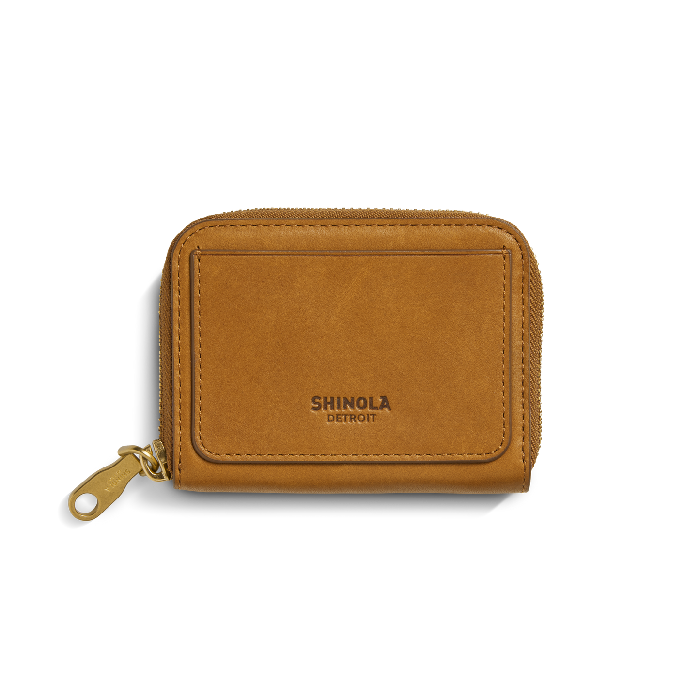 The Shinola Pocket Small Zip Around Wallet in tan natural leather features a gold zipper pull and embossed branding on the front pocket, shown against a white background.
